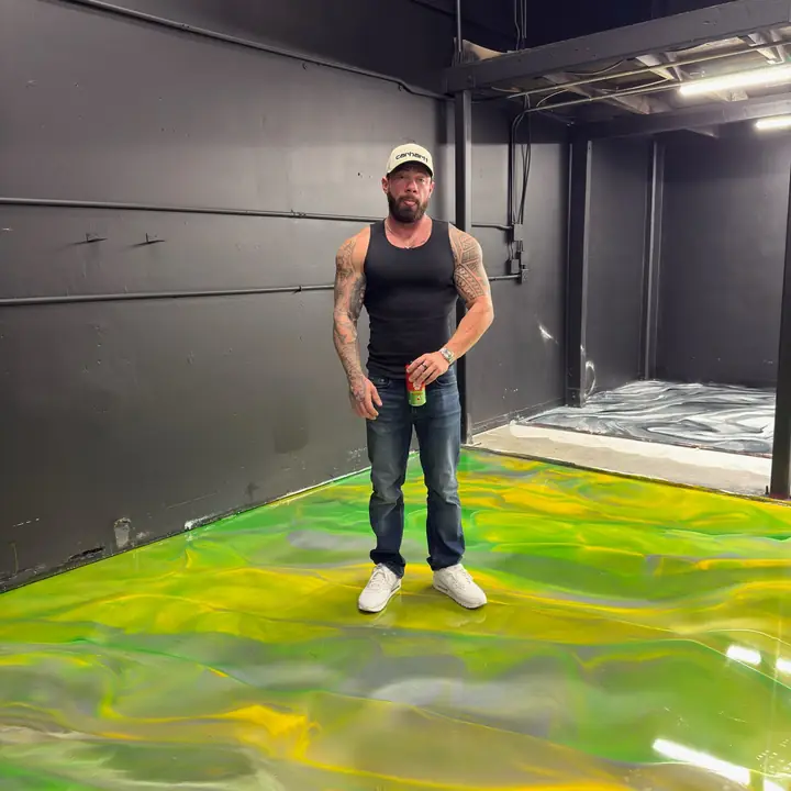 Josh standing on a freshly poured green metallic epoxy floor in San Jose, CA